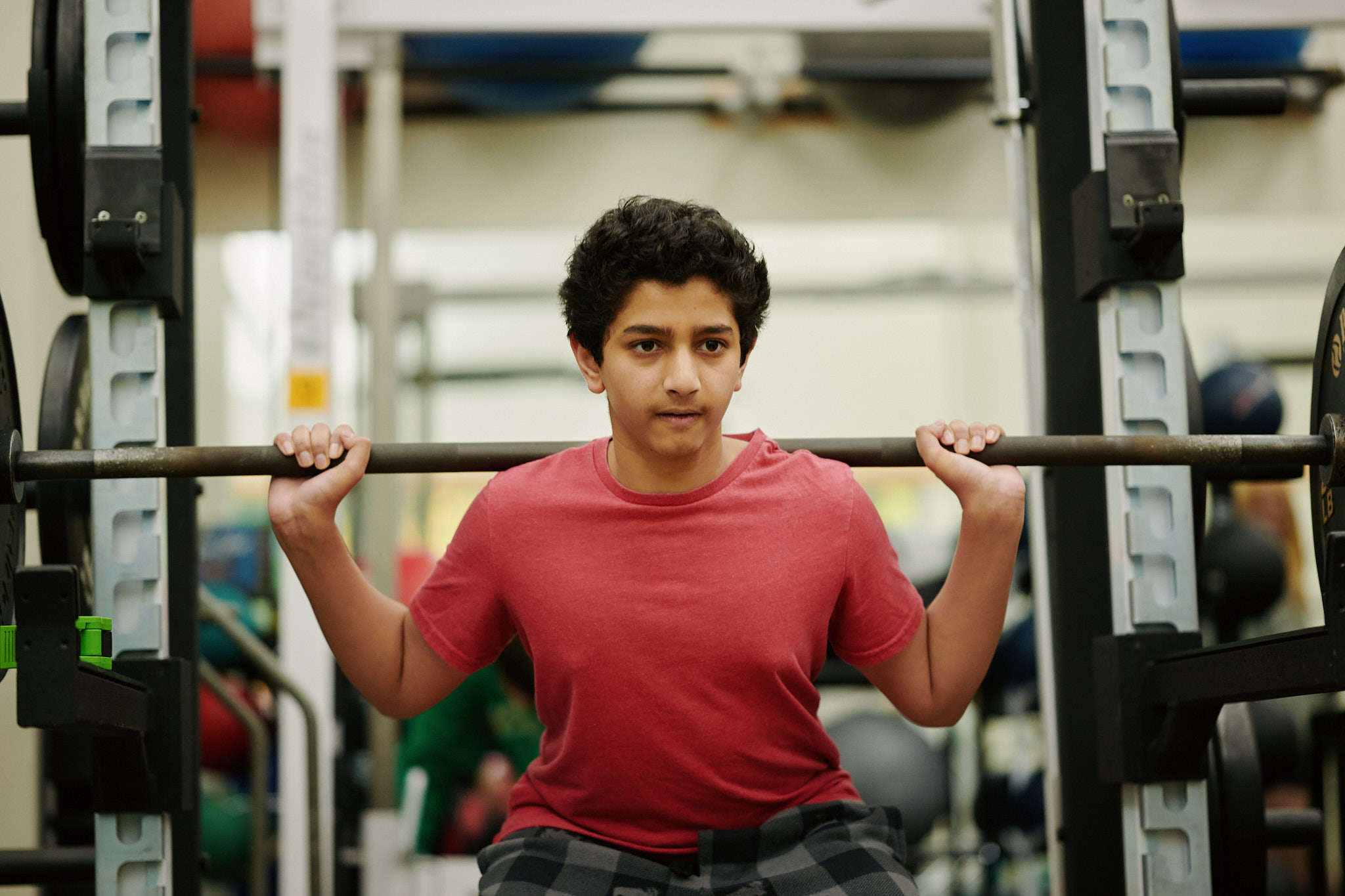 student lifting barbell