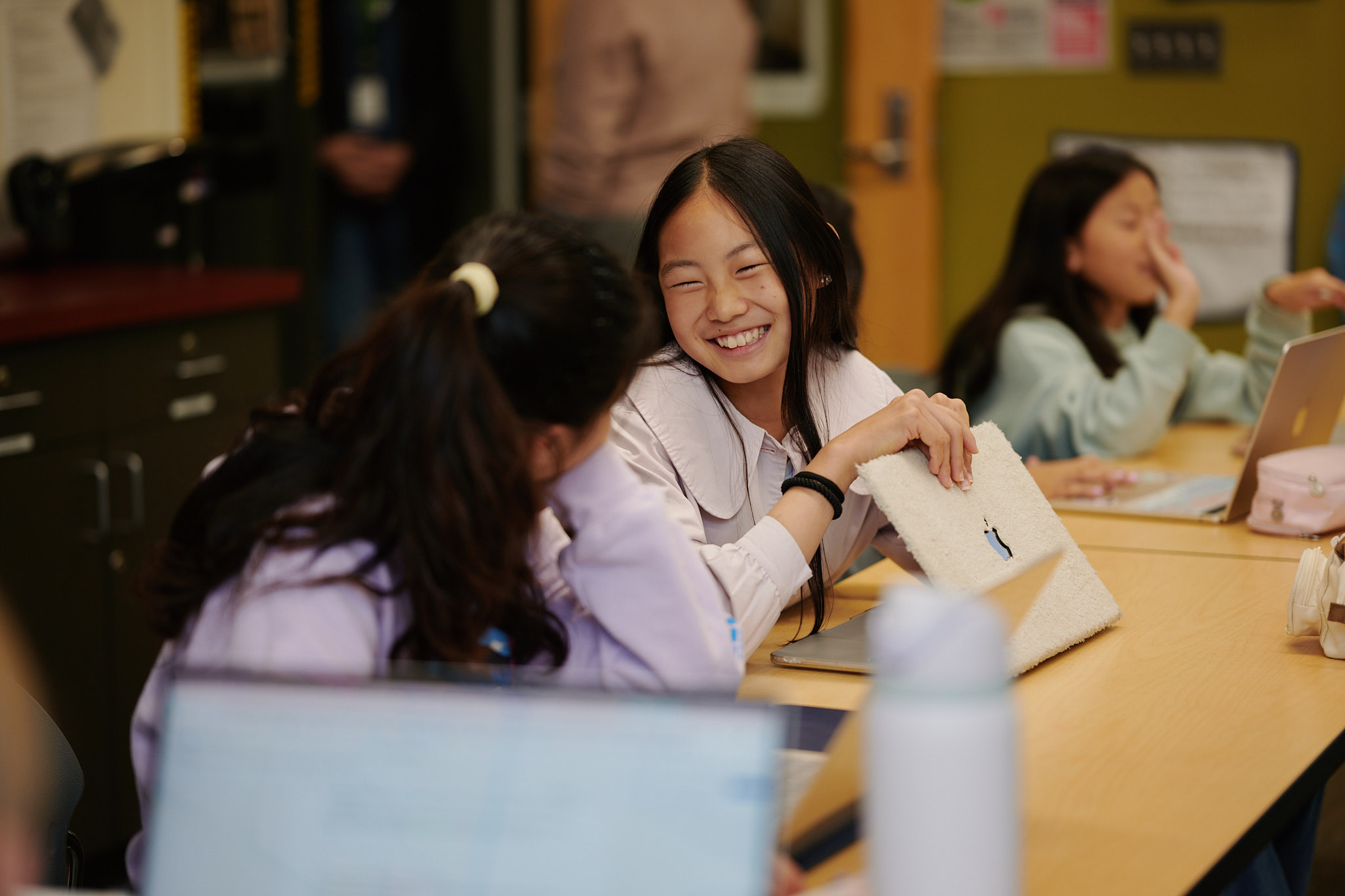 middle school student smiling from desk