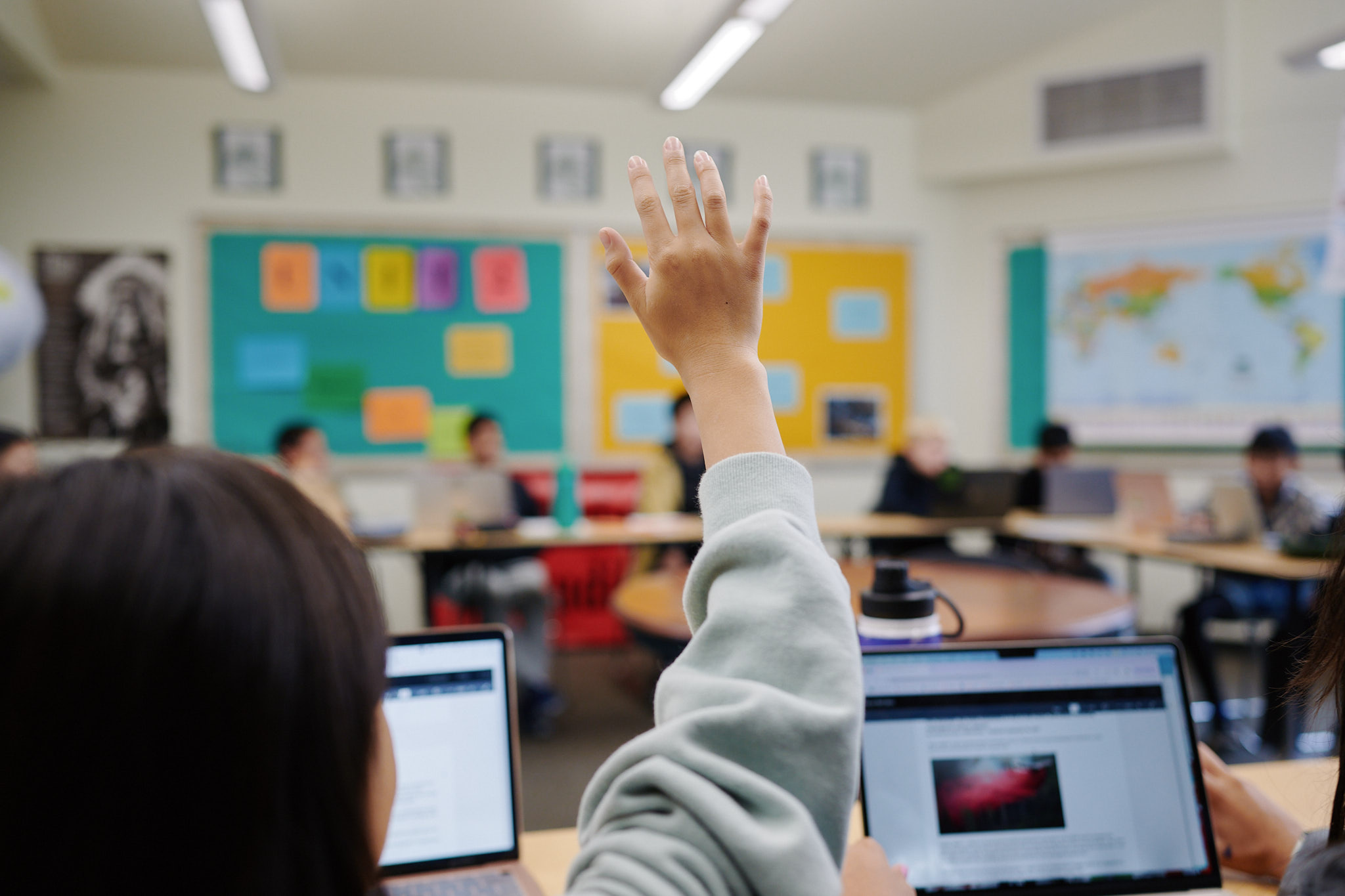 middle school student raising hand in class