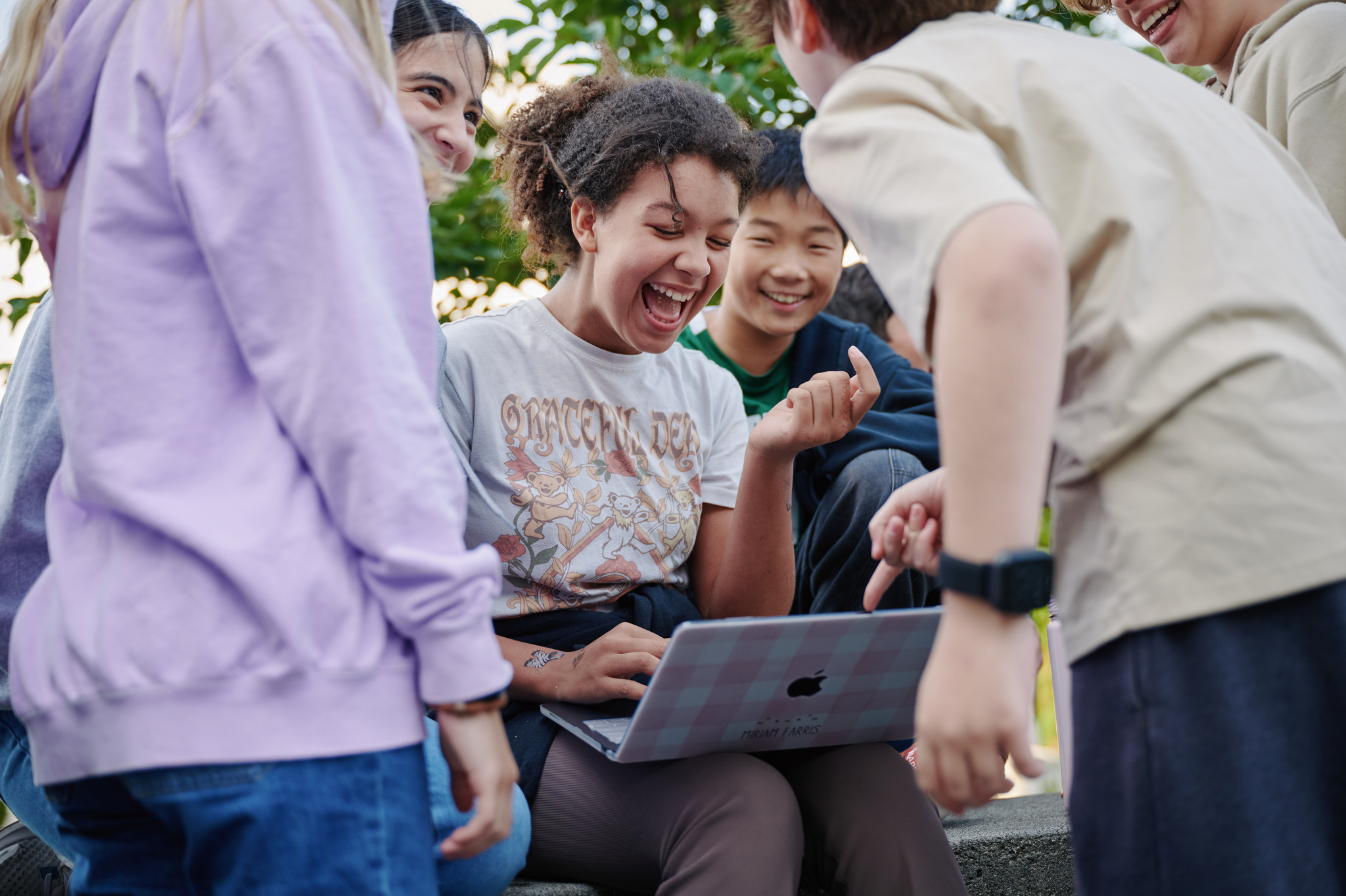 middle school girl laughing at computer screen