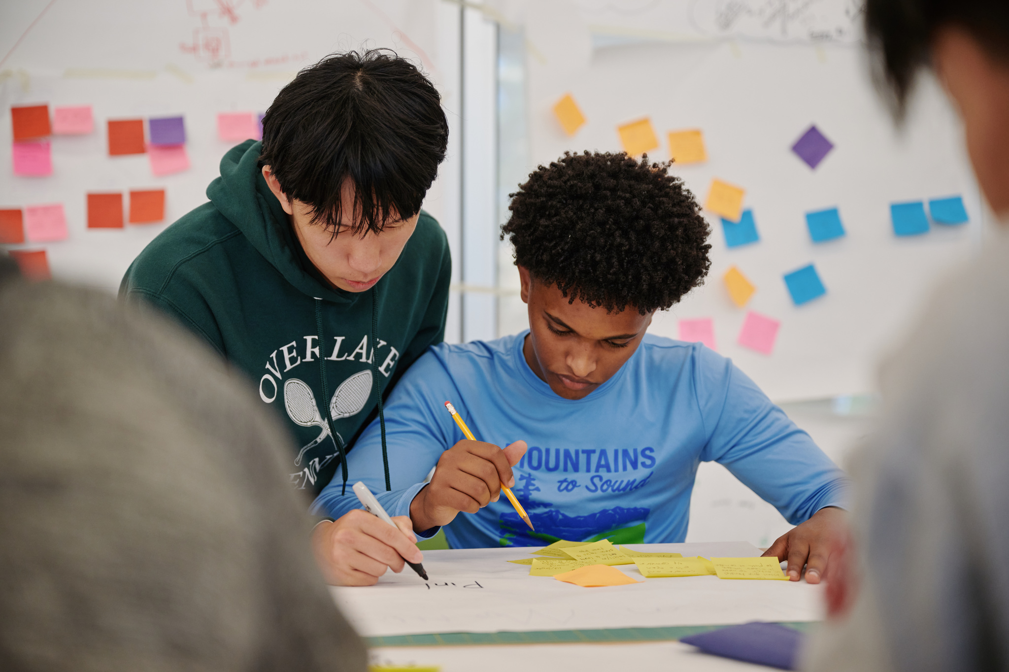 one student helping another student at desk
