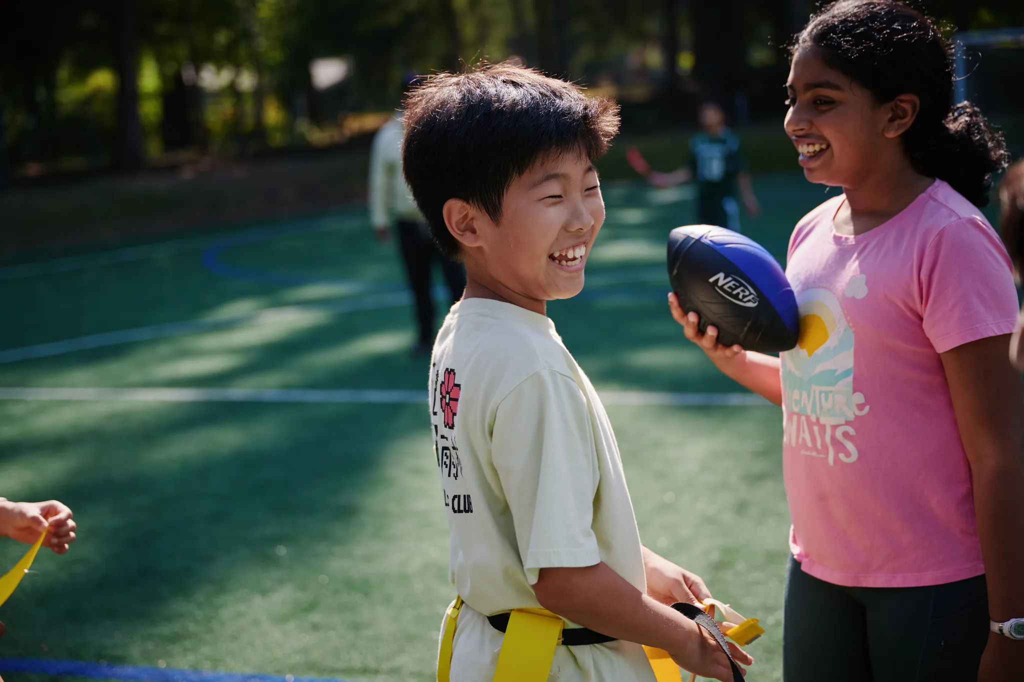 middle school student laughing while playing flag football