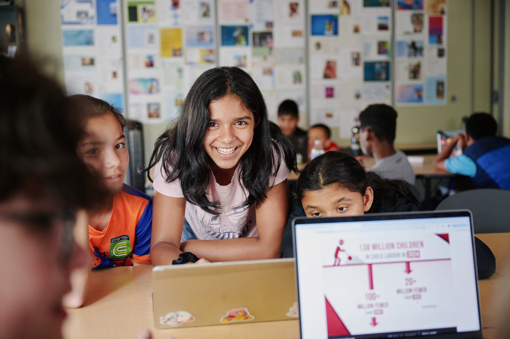 girl smiling at camera around computer