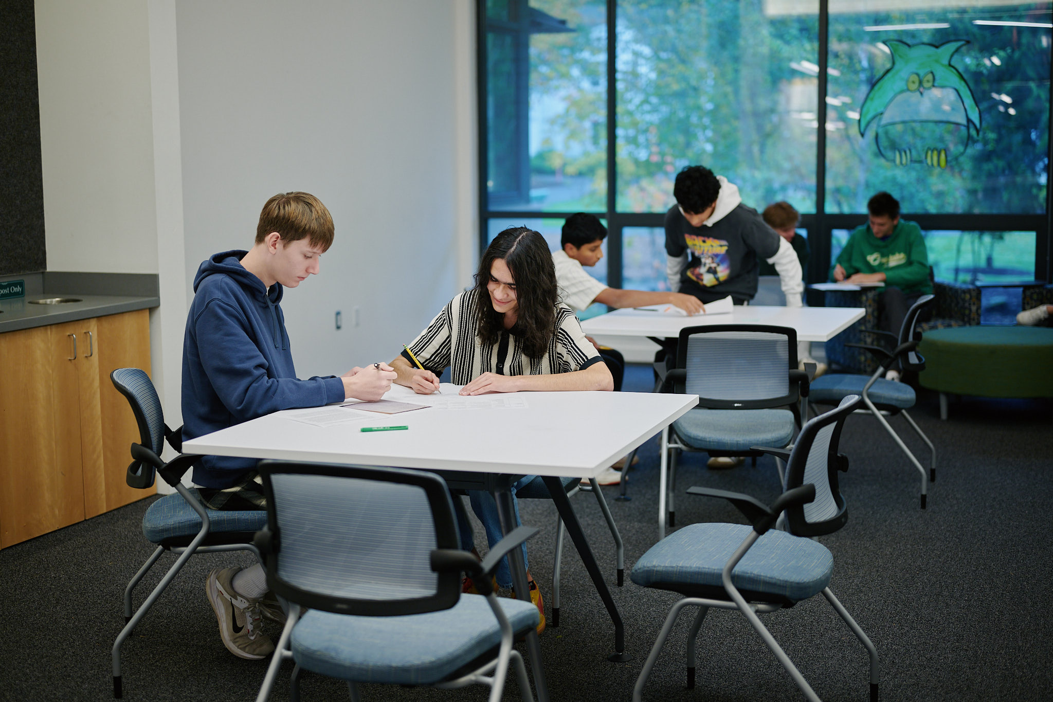 students working at tables in hallway