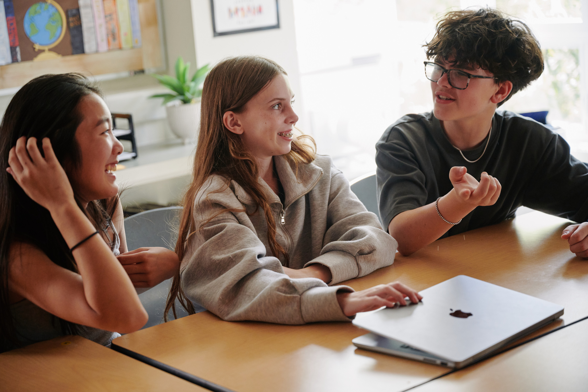 three students laughing in class