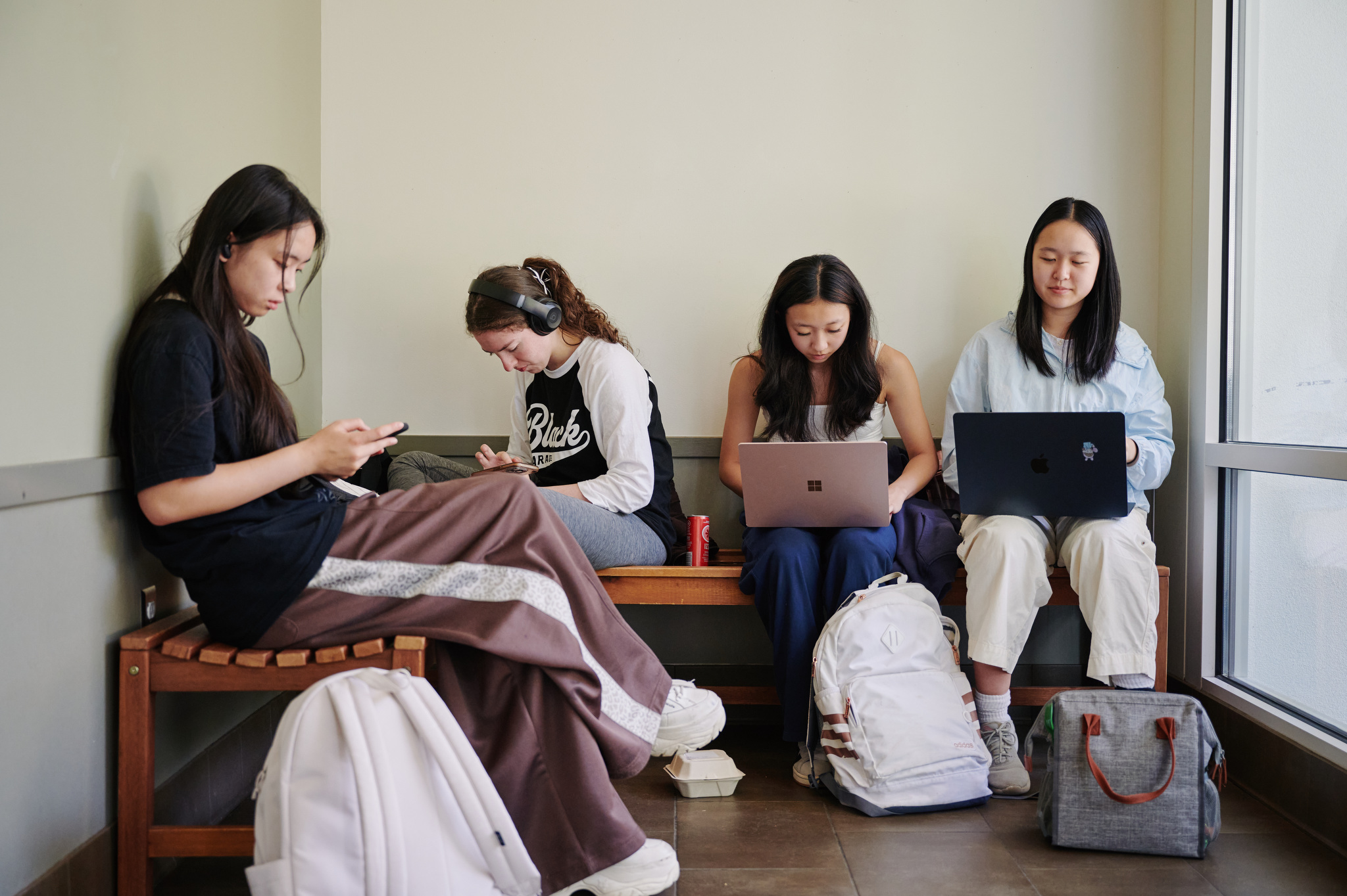 students huddled around computers in lobby of humanities building