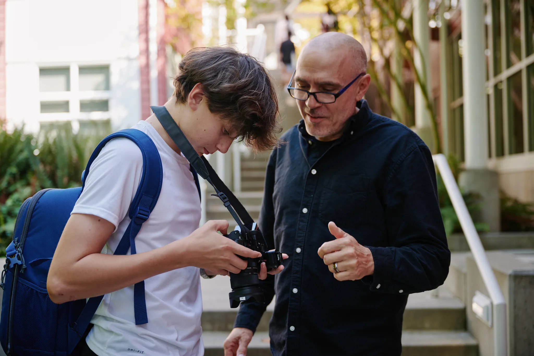 teacher helping student with photography gear