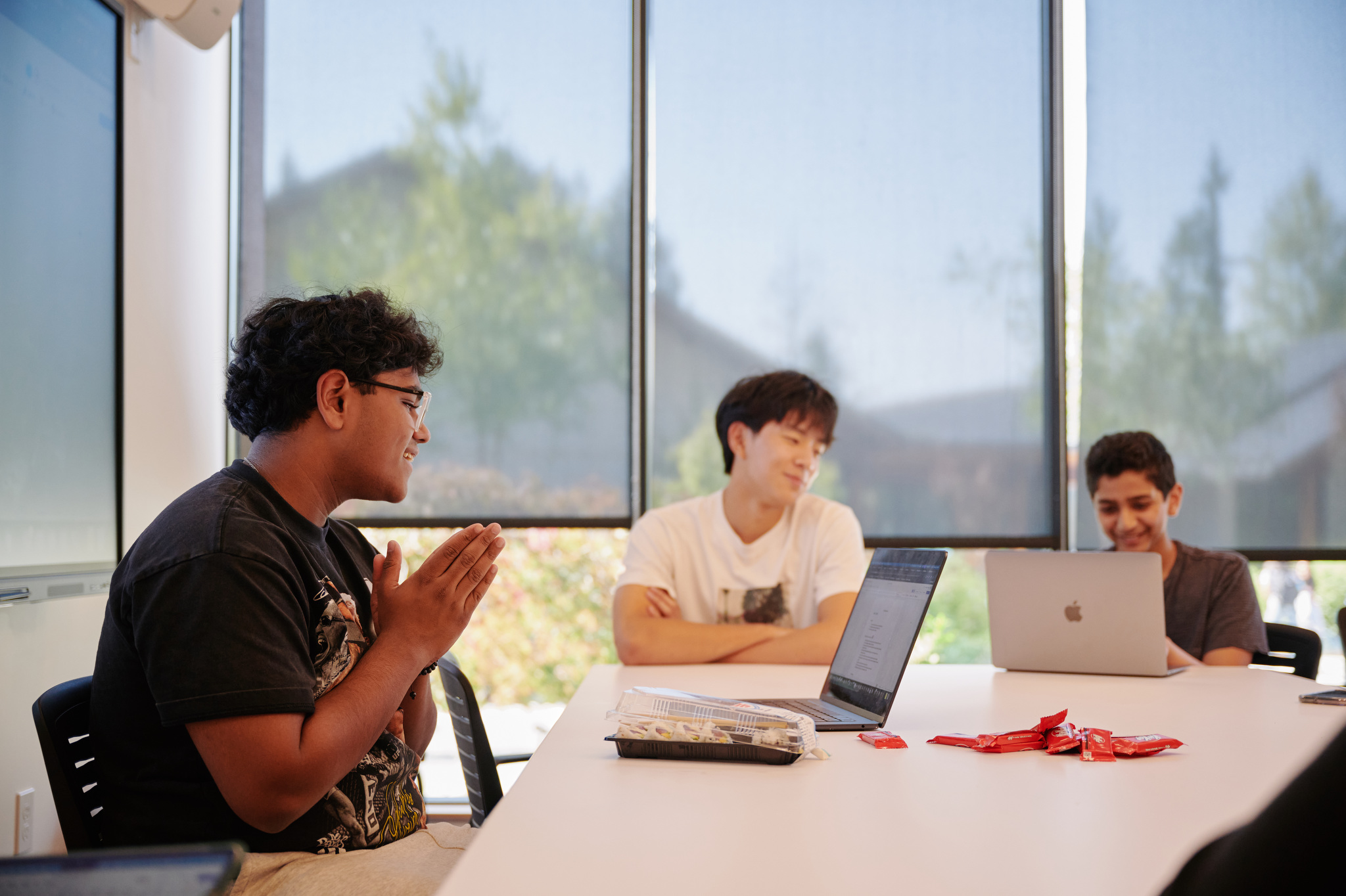 three students around conference table