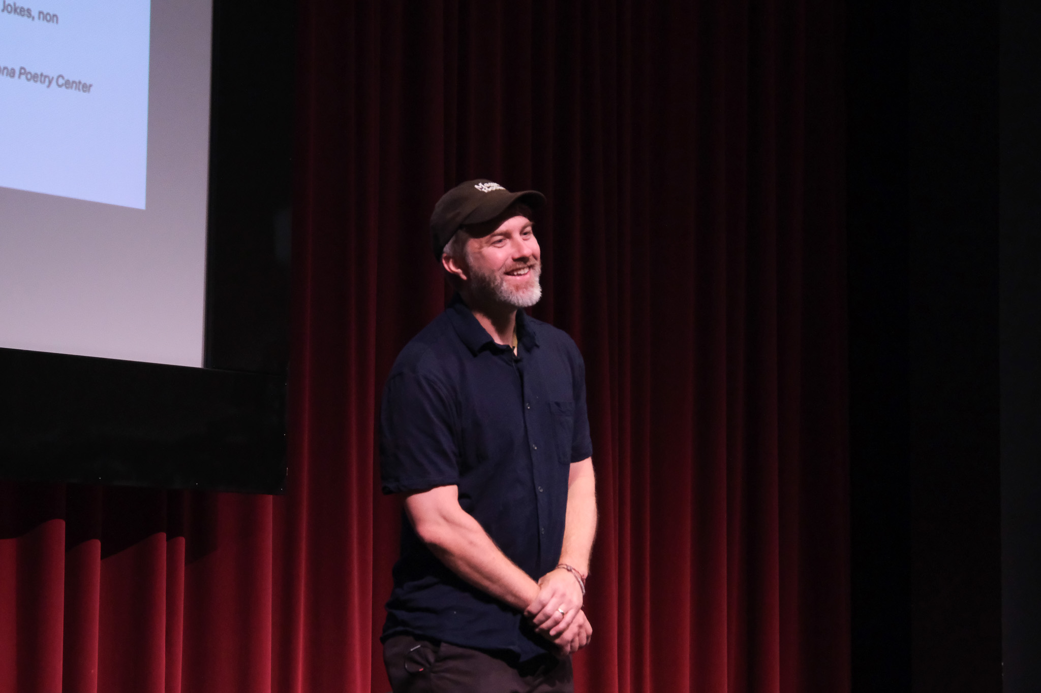 Poet Bill Carty smiles to students while he presents from the Fulton Center Stage.
