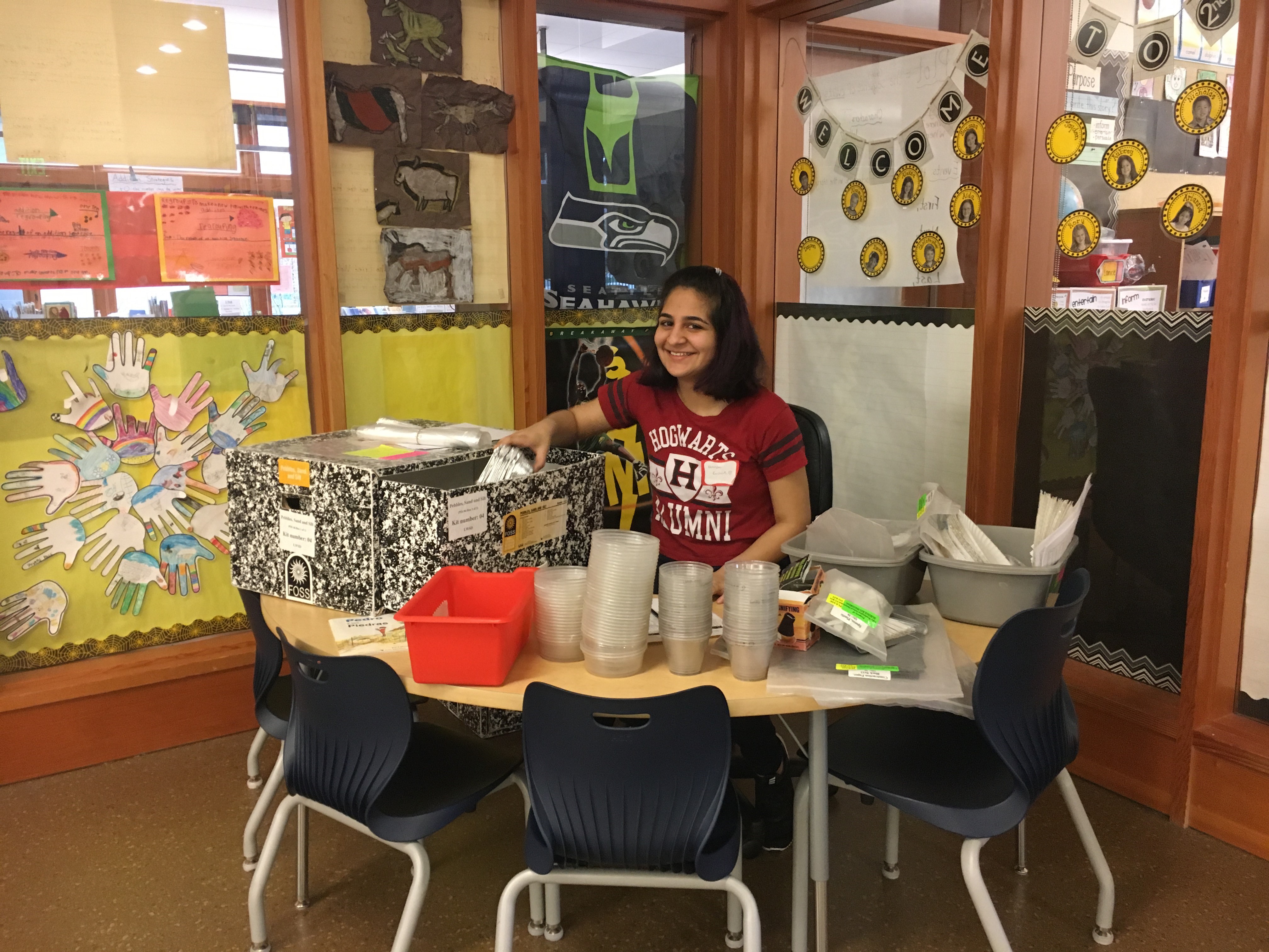 A student prepares science kits for a class.
