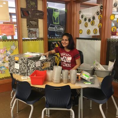 A student prepares science kits for a class.