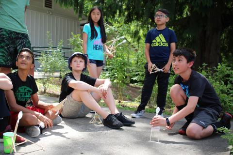 Students watch the marshmallow fly off the catapult