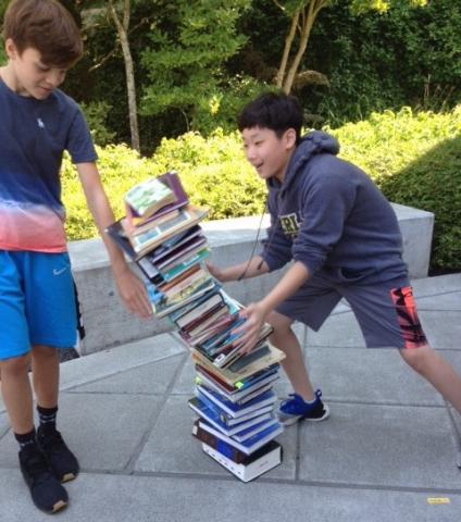 Students knocking over stack of books