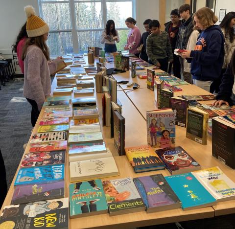 Students around books on table