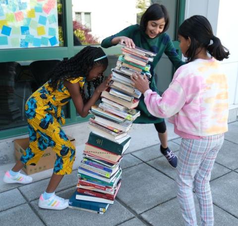 Girls stacking books