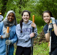 girls smiling with yard tools