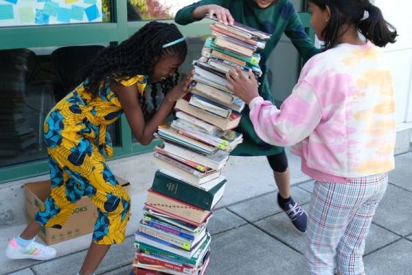 Girls stacking books