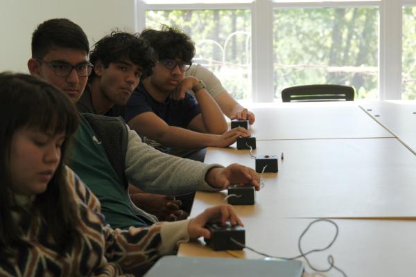 Quiz Bowl members listen to question, hands ready on their buzzers to answer first.